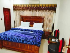 卡拉奇New Royal Residency PECHS的一间卧室配有一张床和一把椅子