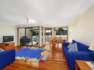 特里格尔Family Beach Retreat in Lovely Terrigal Home的客厅配有蓝色的沙发和蓝色的地毯。