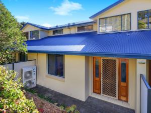 特里格尔Family Beach Retreat in Lovely Terrigal Home的蓝色金属屋顶的房子