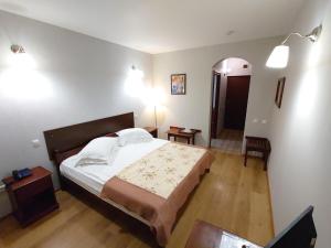 普特纳Pensiunea Mușatinii的一间卧室设有一张大床和一个走廊