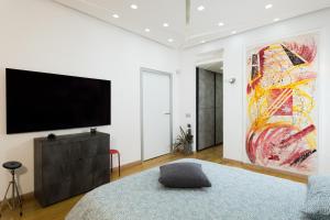 那不勒斯Villa Capri Apartment and Room的卧室配有电视,墙上挂着一幅大画