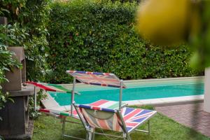 那不勒斯Villa Capri Apartment and Room的游泳池旁的两把草坪椅