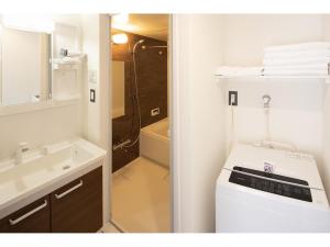 长崎Coruscant Hotel NagasakiekiⅡ的浴室配有盥洗盆、卫生间和浴缸。