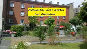 敦刻尔克Hôtel Les Jardins Dunkerque centre的砖楼前的黄色标志
