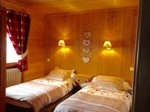 圣母贝莱克托娃赛小木屋酒店的木墙客房的两张床