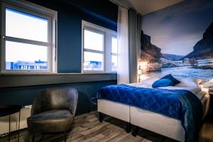阿尔塔Canyon Hotell的一间卧室配有一张床、一把椅子和窗户。