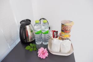 呵叻Ruen Aiyara Apartment的柜台,装有两瓶水和一些鲜花