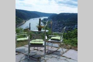 巴哈拉赫Ferienwohnung Rheinblick Bacharach am Rhein的一张桌子和两把椅子,享有河景