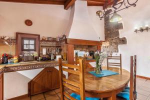 塔科龙特Finca Los Viñedos Casa Rural的一间带木桌的厨房和一间餐厅
