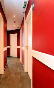 布鲁塞尔月亮酒店的一条带红色墙壁和白色门的走廊