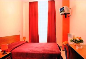 布鲁塞尔月亮酒店的一间卧室设有红色的床和红色窗帘的窗户。
