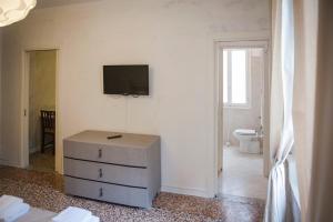 威尼斯威尼斯博尔塔奥里昂塔里斯旅馆的一间房间,墙上装有梳妆台和电视机