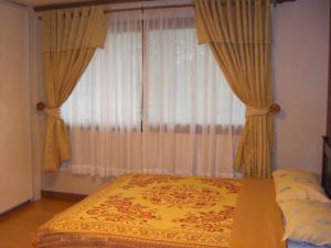碧瑶普雷斯蒂奇假日公寓 - 涵碧庄园的一间卧室配有床和带窗帘的窗户