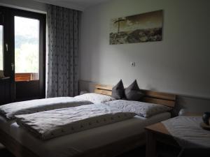 MaurachGästehaus Hechenblaikner的一间卧室设有两张单人床和一个窗户。
