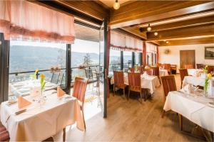 博伦多夫索娜伯格瓦尔德酒店的餐厅设有白色的桌椅和窗户。