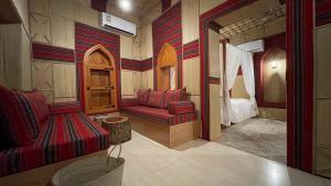 马斯喀特Fort Guesthouse نُزل القلعة的客厅配有红色的沙发和床。
