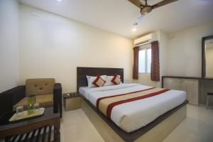 钦奈Balaji residency的一间卧室配有一张床、一张桌子和一个窗户。