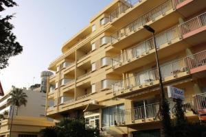 罗克布吕讷-卡普马丹 亚历山德拉酒店的黄色的公寓大楼设有阳台和街灯