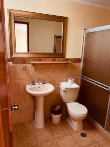 阿亚库乔塞维利亚酒店的一间带水槽、卫生间和镜子的浴室