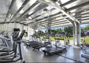 科洛阿ALOHA - Poipu Beach Vacation Condo的健身房设有跑步机和椭圆机