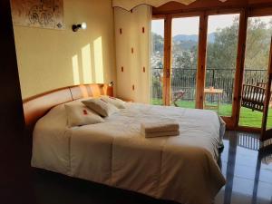 San Fausto de CampcentellasHabitaciones en Villa Coliving Casa Rural的一间卧室配有一张带白色床单和窗户的床。
