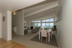 Doubtless Bay Retreat的用餐室以及带桌椅的起居室。