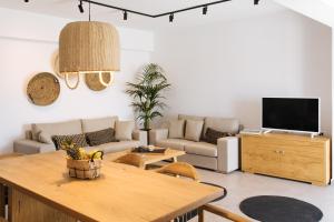 弗通Amer Villa Santorini with outdoor hot tub的客厅配有沙发和桌子
