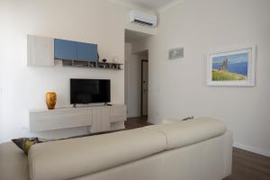 雷焦卡拉布里亚La Casa di Nausicaa : il piacere dell'ospitalità的白色的客厅配有白色的沙发和电视