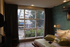 非斯Luxury Appartement Noor的一间卧室设有大窗户、一张床和一张沙发