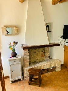 马切拉塔CIRIBACCO ROOMS的客厅设有砖砌壁炉和桌子