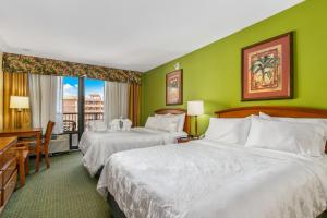 克利尔沃特Holiday Inn & Suites Clearwater Beach, an IHG Hotel的绿墙旅馆客房的两张床