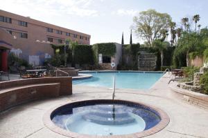 土桑Ramada by Wyndham Viscount Suites Tucson East的庭院中带喷泉的游泳池