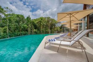 格拉玛多Wyndham Gramado Termas Resort & Spa的一个带躺椅和遮阳伞的游泳池