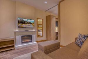 格拉玛多Wyndham Gramado Termas Resort & Spa的带沙发和壁炉的客厅