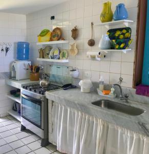 累西腓Casa Pontal dos Carneiros - Praia dos Carneiros的厨房配有水槽、炉灶和架子