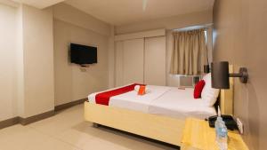 马尼拉RedDoorz at Samat Mandaluyong的卧室配有一张床,墙上配有电视。