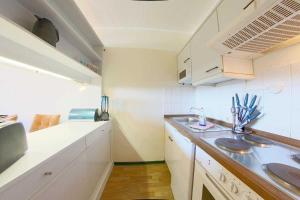 霍盖思Apartment 581的小厨房配有白色橱柜和水槽