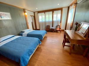南邦ท่ามะโอบูทีคโฮมสเตย์ Tha Ma-O Bouteak Homestay的酒店客房配有两张床和一张书桌