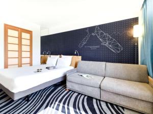 拉罗谢尔拉罗谢尔中心诺富特酒店的酒店客房,配有床和沙发