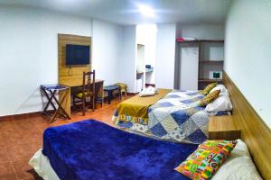 伊瓜苏港Mediterráneo Suites的一间设有两张床和一张桌子的房间,一间设有