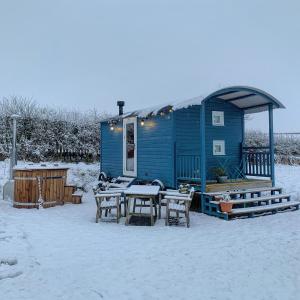 罗斯伯里韦斯特菲尔德农场旅馆的雪地里带桌椅的蓝色房子