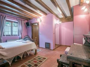 MallaviaHotel Rural Mañe的一间拥有紫色墙壁的卧室和一张位于客房内的床