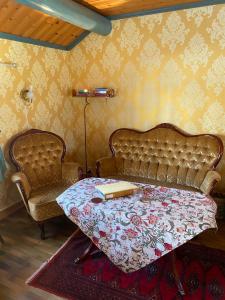 法伦Olsbacka cottage的一间卧室配有一张床和一把椅子,上面有一本书