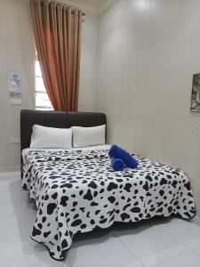 瓜拉勿述Desa Besut Inn的一张黑白的睡床,上面有蓝色泰迪熊