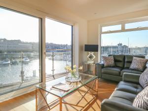 韦茅斯Harbourside Haven Apartment 3的带沙发和玻璃桌的客厅