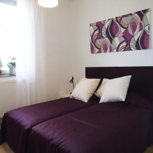 博里霍尔姆诺尔别墅 的一间卧室配有一张带两个枕头的紫色床