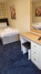 伯明翰The Aston Inn的客房设有两张床、一张桌子和一面镜子。