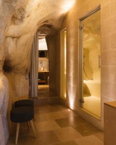 马泰拉La Corte Dei Pastori Luxury的一间设有岩石墙和椅子的房间