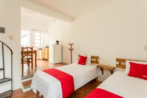 San Agustín EtlaHotel Paraje Casa Blanca的一间卧室配有两张红色和白色床单