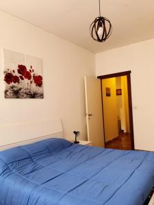 拉帕洛中心之家公寓的一间卧室配有蓝色的床和红色鲜花画